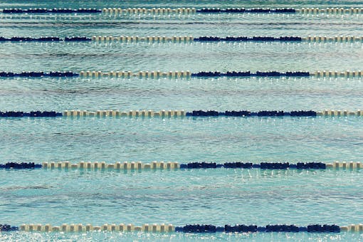 A tranquil view of an empty Olympic swimming pool with lane dividers.