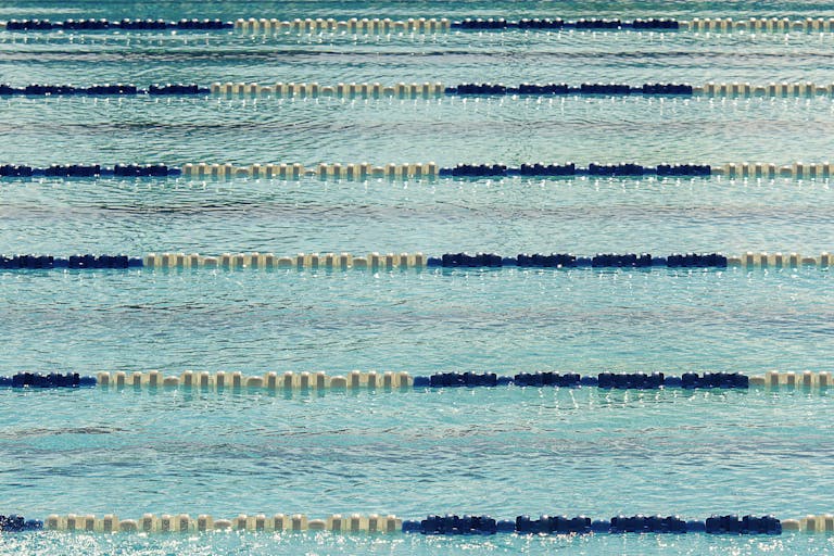 A tranquil view of an empty Olympic swimming pool with lane dividers.