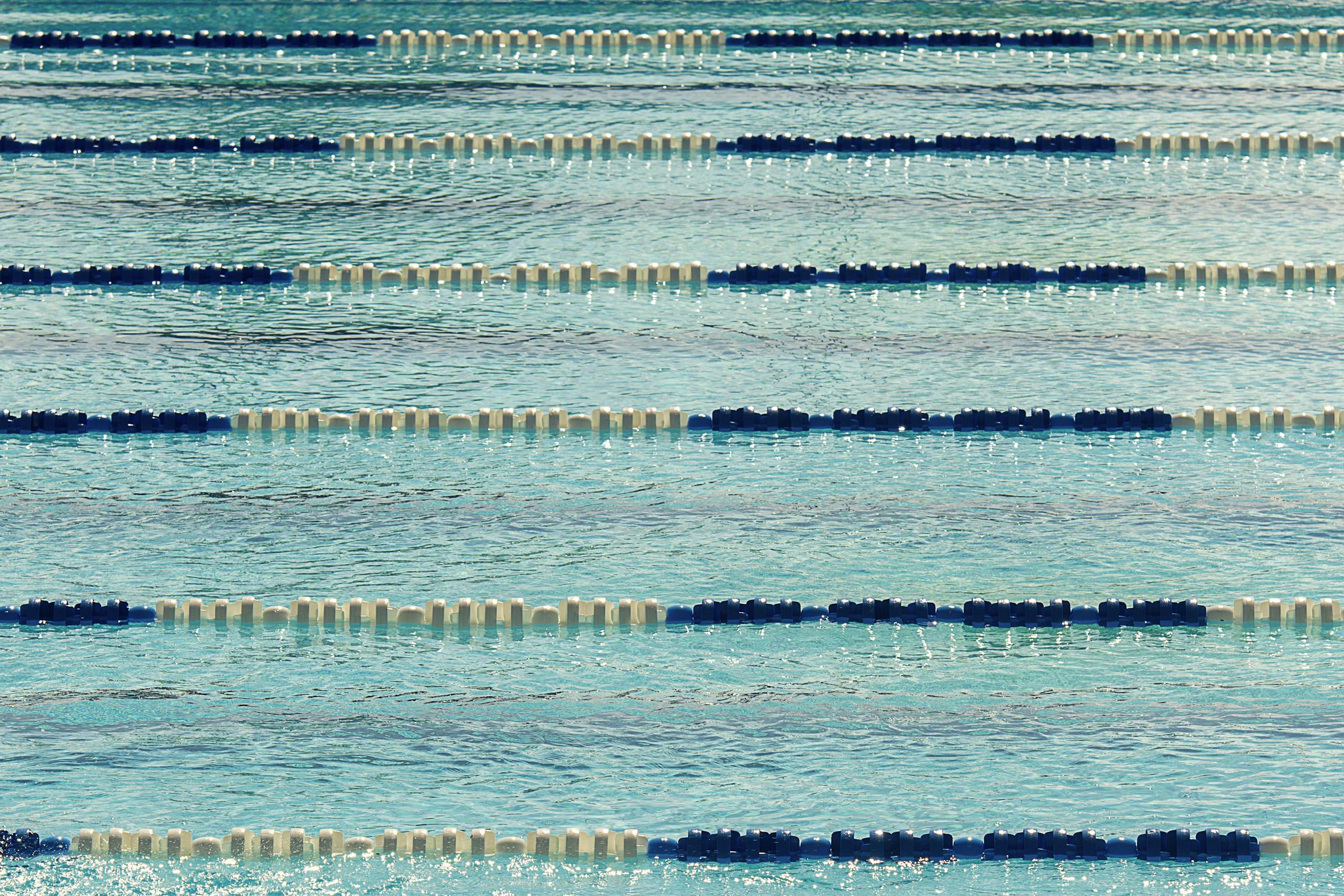A tranquil view of an empty Olympic swimming pool with lane dividers.